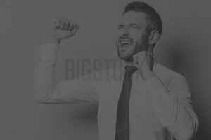 Man celebrating success with raised fists.