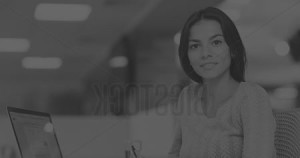 Smiling woman sitting at office desk.